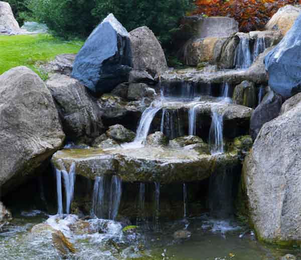 Jolie cascade en pierre sur plusieurs niveau dans un jardin japonais